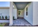 Covered front porch with tile flooring and access to the front door at 11243 Boundless Ter, Venice, FL 34293