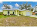 Bright yellow house with a two-car garage and well-manicured lawn at 11247 Euler Ave, Englewood, FL 34224