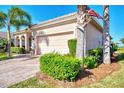 Attached garage with paver driveway and manicured landscaping at 12953 N Marsh Dr, Port Charlotte, FL 33953