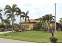 Tan house with brown roof and lush landscaping, including palm trees at 170 Antilla Dr, Rotonda West, FL 33947