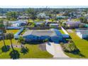 Aerial view of a light blue house with a large yard and solar panels at 221 E Wentworth St, Englewood, FL 34223