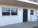 Condo entrance with a dark door and two windows at 244 Saint Augustine Ave # 102, Venice, FL 34285