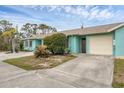 Exterior of light teal home with attached garage and partial view of driveway at 255 Boundary Blvd # 104, Rotonda West, FL 33947
