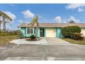 Cute teal home with a one-car garage and well-maintained landscaping at 255 Boundary Blvd # 105, Rotonda West, FL 33947