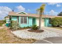 Quaint teal home with a one-car garage and nicely landscaped front yard at 255 Boundary Blvd # 105, Rotonda West, FL 33947