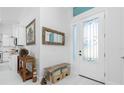 Entryway with white door, bench, and view into the kitchen at 275 Broadmoor Ln, Rotonda West, FL 33947