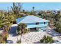 Aerial view of a light blue house with metal roof and tropical landscaping at 396 N Gulf Blvd, Placida, FL 33946