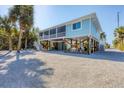 Elevated beach house exterior with screened porch and tropical landscaping at 396 N Gulf Blvd, Placida, FL 33946