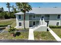 Two-story condo building with stairs, balconies, and lush landscaping at 8050 Memory Ln # 104, Rotonda West, FL 33947