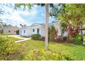 Side view of a single story home showcasing landscaping and a walkway at 860 Knights Ln, Englewood, FL 34223