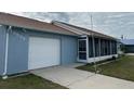 Cute light blue home with a screened porch and one car garage at 13537 Bennett Dr, Port Charlotte, FL 33981