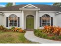 House entrance with green double doors and walkway at 1873 Whispering Pines Cir, Englewood, FL 34223