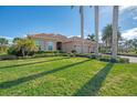 Tan house with tile roof, shutters, lush landscaping, and palm trees at 2744 Mill Creek Rd, Port Charlotte, FL 33953