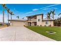 Two-story home with a metal roof, artificial turf, and a spacious driveway at 3015 Curry Ter, Port Charlotte, FL 33981
