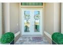 Front entrance with double doors and lush landscaping at 4 White Marsh Ln, Rotonda West, FL 33947