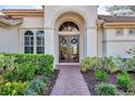 Elegant entryway with double doors and a brick walkway, enhancing the home's charm at 4233 Grosse Pointe Dr, Port Charlotte, FL 33953