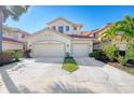 Tan three-story townhome with two-car garage and manicured lawn at 4628 Club Dr # H201, Port Charlotte, FL 33953