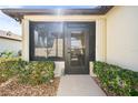 Front entrance with a screened porch and well-manicured landscaping at 601 Linden Dr, Englewood, FL 34223