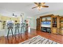 Living room with hardwood floors, a large TV, and comfortable seating at 6153 Pennell St, Englewood, FL 34224