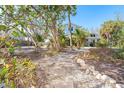 Pathway leading to beach house through tropical landscape at 7630 Manasota Key Rd, Englewood, FL 34223