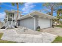 Gray house with white garage door and walkway leading to the entrance at 900 Oxford Dr, Englewood, FL 34223