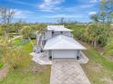 Two-story house with attached garage, paved driveway and tropical landscaping at 900 Oxford Dr, Englewood, FL 34223