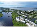 Community of townhouses near the water, with lush landscaping and a view of the coastline at 10360 Longshore Rd # 66, Placida, FL 33946