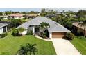 One-story house with a spacious yard, driveway, and surrounding houses at 1042 Boundary Blvd, Rotonda West, FL 33947