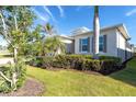 Landscaped front yard with lush greenery and palm trees at 10479 Coquina Ct, Placida, FL 33946
