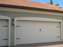 Three-car garage with white doors and black accents at 10705 Tarflower Dr, Venice, FL 34293