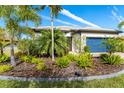 Landscaped front yard with tropical plants and a one-story house at 1506 Hyssop Loop, North Port, FL 34289
