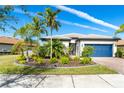 One-story home with lush landscaping and a blue garage door at 1506 Hyssop Loop, North Port, FL 34289