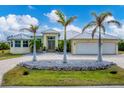 House exterior featuring a double-car garage, palm trees, and a paved driveway at 15228 Chinook Way, Port Charlotte, FL 33981