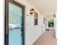 Close-up of entrance featuring a storm door, classic lantern, and a brick walkway for welcoming curb appeal at 1730 Manasota Beach Rd # 110, Englewood, FL 34223