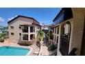 Inviting pool area with surrounding building and lush tropical landscaping at 1760 Gulf Blvd # 511, Englewood, FL 34223
