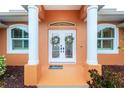 Double front doors with wreaths, a doormat, and columns at 2194 Wenona Dr, North Port, FL 34288