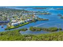 Stunning aerial view of waterfront condo complex with boat docks and lush landscaping on the water at 2424 Placida Rd # C101, Englewood, FL 34224