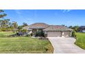 Single-story house with a two-car garage and well-maintained lawn at 252 Medalist Rd, Rotonda West, FL 33947