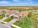 Aerial view of a tan house near a pond at 26906 Weiskopf Dr, Englewood, FL 34223