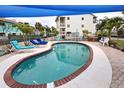 Inviting kidney-shaped pool with brick coping and shade structure at 5031 N Beach Rd # 112, Englewood, FL 34223
