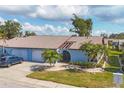 Cute light blue house with a two-car garage and lush landscaping at 610 Apple Ln, Englewood, FL 34223