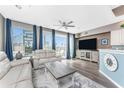 Bright and airy living area with hardwood floors, large TV, and access to balcony at 8226 Harborside Cir, Englewood, FL 34224