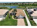 Aerial view of single-Gathering house with tile roof, landscaping, and paver driveway at 8596 Lakeside Dr, Englewood, FL 34224