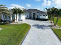 Inviting one-story home with manicured lawn, a paver driveway, and tropical landscaping at 1061 Boundary Blvd, Rotonda West, FL 33947