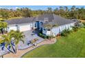 Expansive light blue home with a paver driveway, mature palm trees, and lush landscaping at 1061 Boundary Blvd, Rotonda West, FL 33947