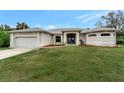 Single-story home with attached garage and well-manicured lawn at 13235 Essman Ave, Port Charlotte, FL 33953