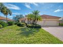 Single-story house with a red tile roof, palm trees, and a brick driveway at 14173 Myakka Pointe Dr, Port Charlotte, FL 33953