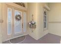 Beige front door with sidelights and a charming floral wreath at 14173 Myakka Pointe Dr, Port Charlotte, FL 33953