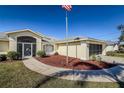 Front view of a single-story house with a walkway and American flag at 152 Sportsman Rd, Rotonda West, FL 33947