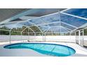 Kidney-shaped screened pool with a spacious deck at 1600 Thomas St, Englewood, FL 34223